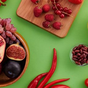 A vibrant display of fresh fruits and vegetables on a green surface.